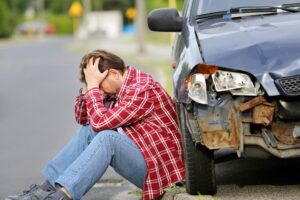 A man keeping his hand on the head after serious car accident on the road