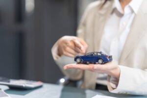 A female lawyer holding blue toy car on her hand