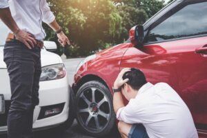 Two drivers man arguing after a car traffic accident collision