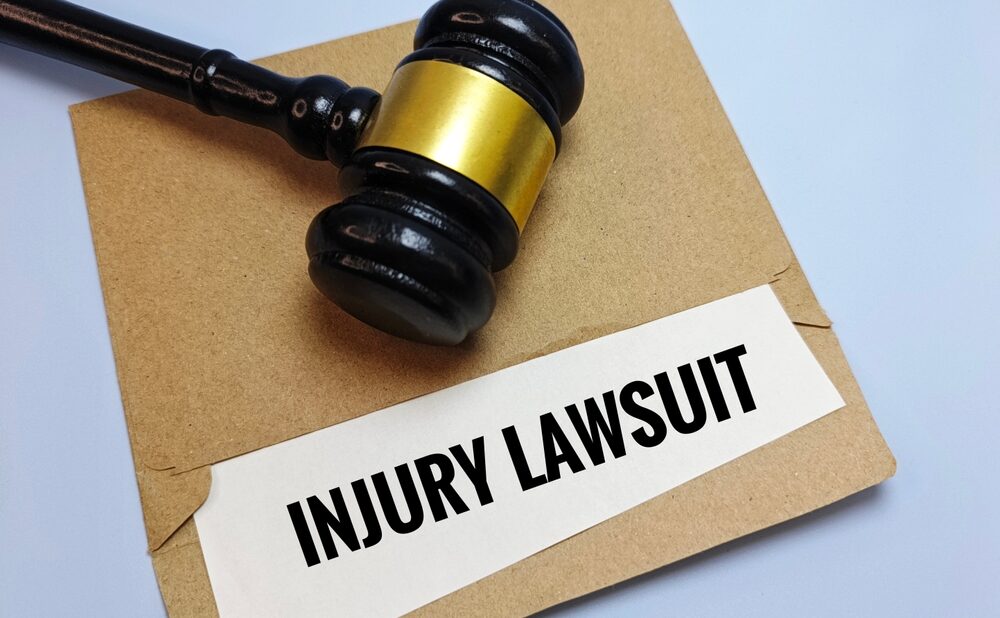 Gavel resting on an envelope labeled Injury Lawsuit, representing personal injury lawsuit steps.